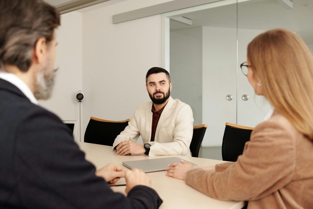 man-in-white-suit-sitting-on-chair-with-people