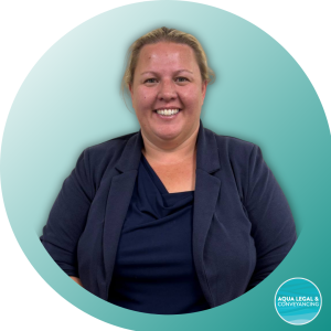 Lucy, Solicitor at Aqua Legal, specialising in contested estates and estate planning, sitting at her desk with a warm smile.