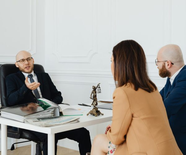 Photo by Photo By Kaboompics.com httpswww.pexels.comphotoa-couple-talking-to-a-lawyer-7876315 Lawyer talking a client sitting at the office